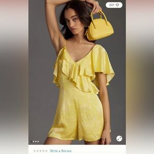Yellow asymmetrical romper with ruffle sleeve.